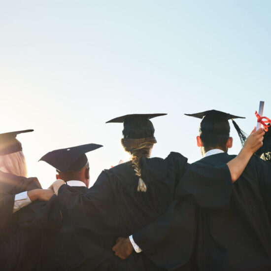 Rearview shot of a group of university students standing outside on graduation day
